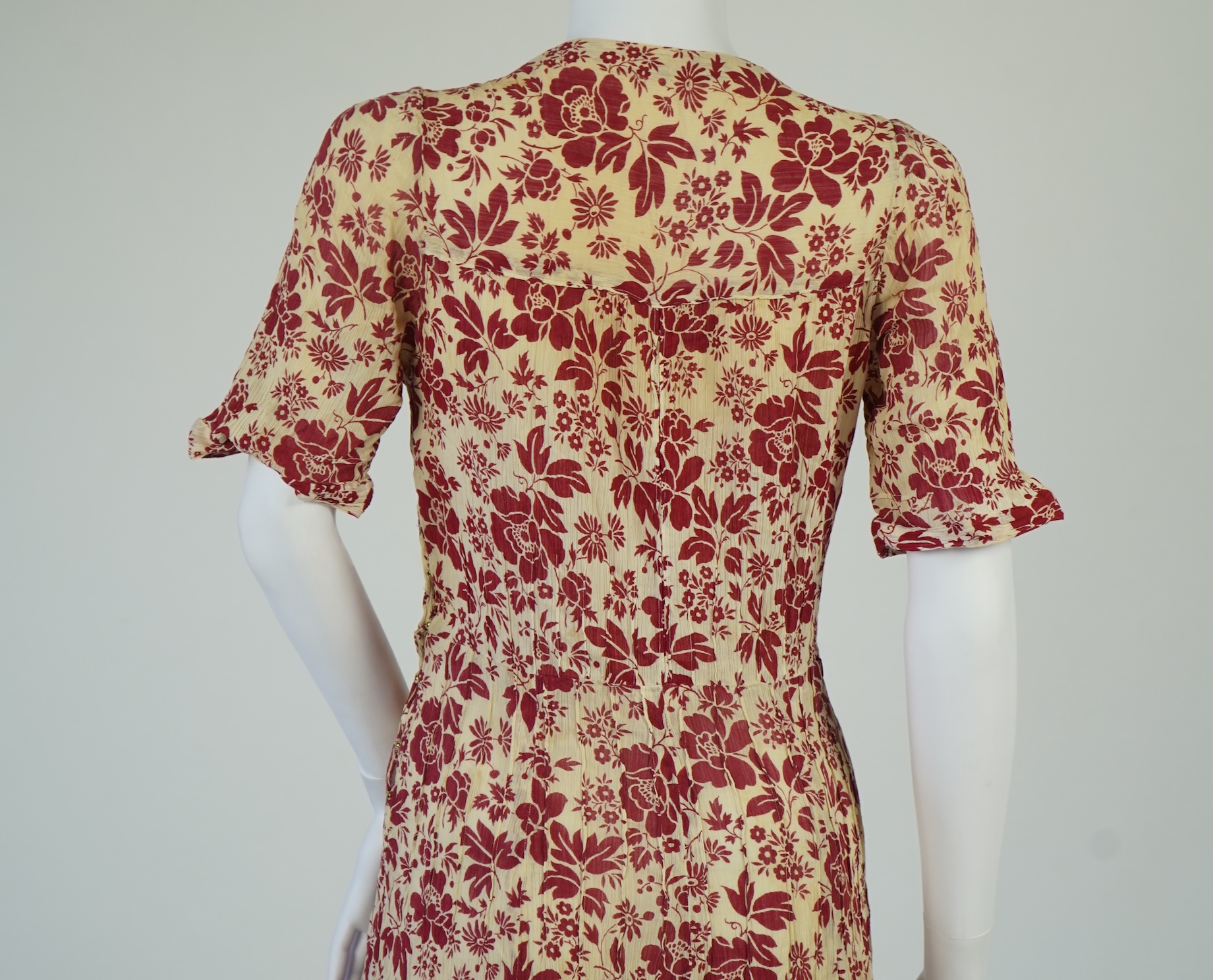 Two 1930's printed silk crepe summer day dresses together with a similar pale blue and black stripped summer day dress., Condition - the maroon and cream dress has damage to one sleeve, the green dress has worn under the